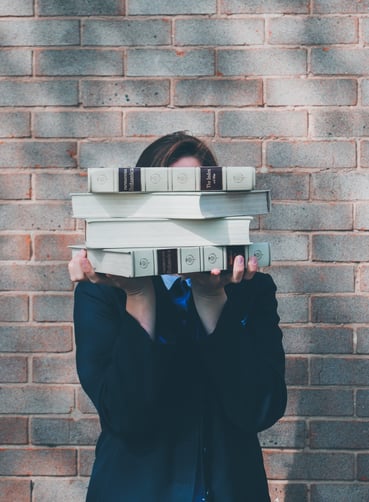 Person holding a stack of books